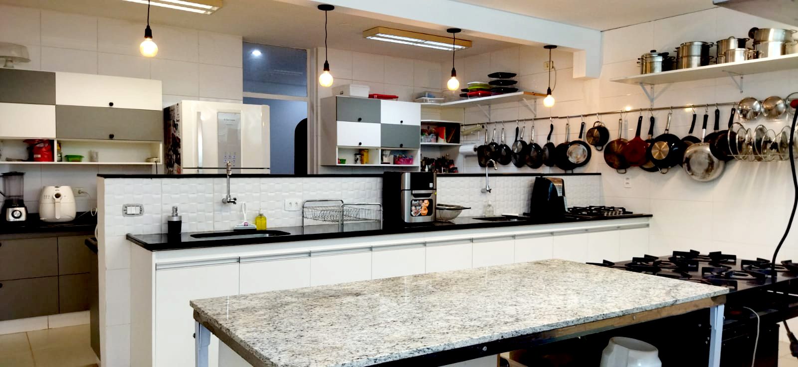 Cozinha industrial equipada, com bancada de granito e fogões