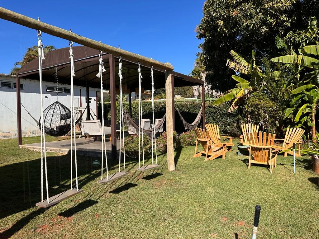 Jardim com balanços, redes e cadeiras de madeira
