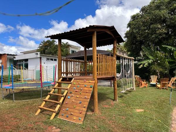 Parquinho com parede de escalada, balanços e cama elástica