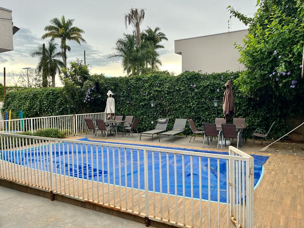 Piscina, deck e jardim com cerca viva florida