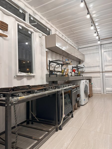 Cozinha industrial equipada, com bancadas de inox e máquina de lavar