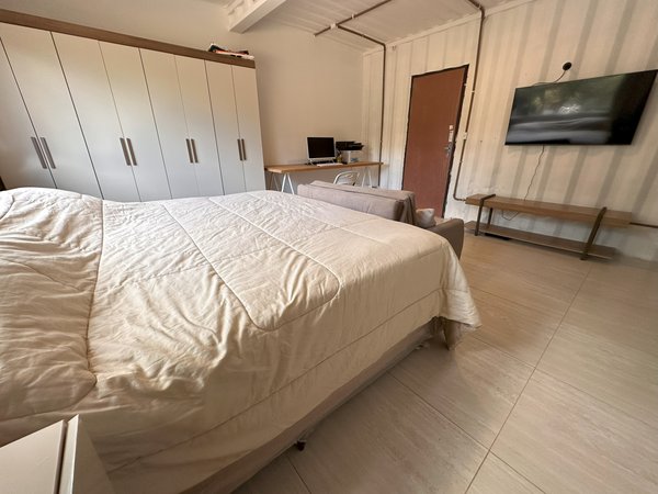 Quarto com armário embutido, televisão e cama de casal