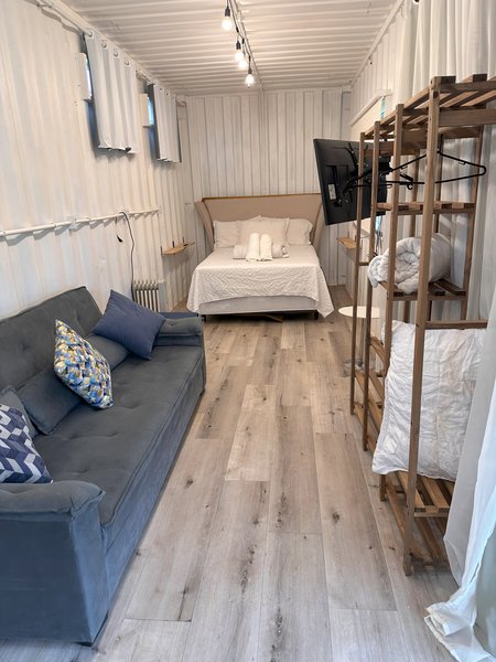 Estar com sofá, cama de casal e beliche no mesmo ambiente