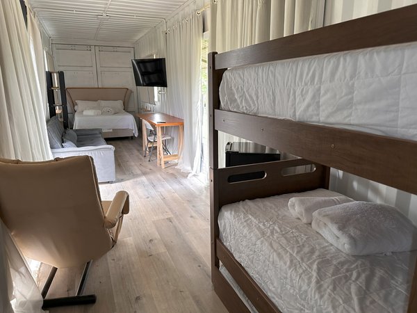 Quarto da Villa Catetinho com cama, beliche e televisão