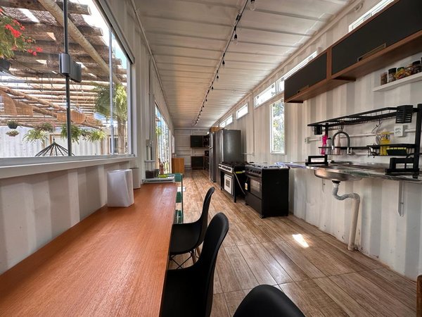 Cozinha nova com bancada, cooktop e janela para a área externa