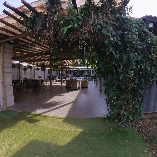 Entrada de la Villa Kubitschek bajo la pérgola cubierta de enredaderas