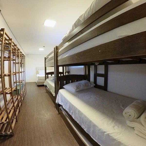 Flat da Família bedroom with bunk bed, shelving and a double bed in the background