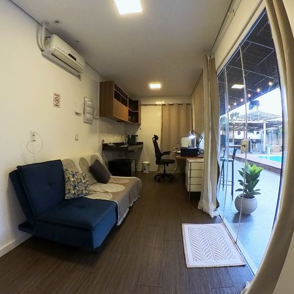 Sala del Flat dos Solteiros con sofá y cocina compacta