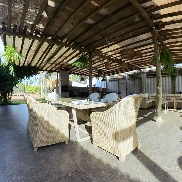 Mesa de comedor de mimbre bajo la pérgola