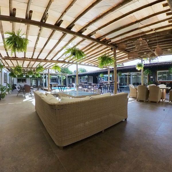 Salón con sofás de mimbre en el patio cubierto