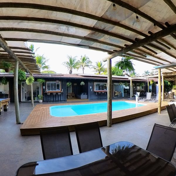 Piscina con terraza de madera y tumbonas
