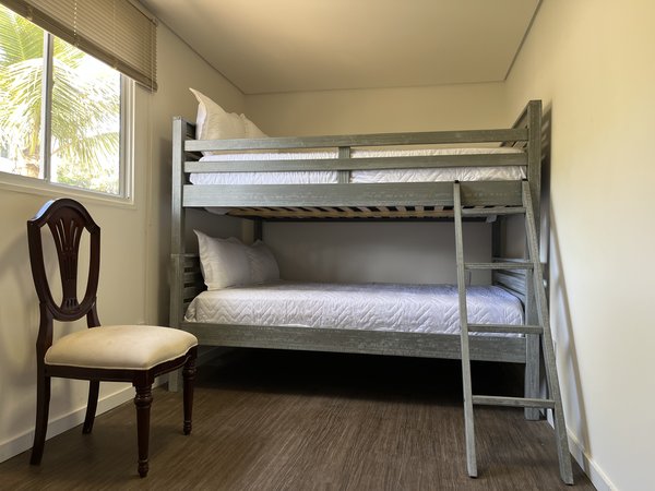 Quarto com beliche e janela para as palmeiras