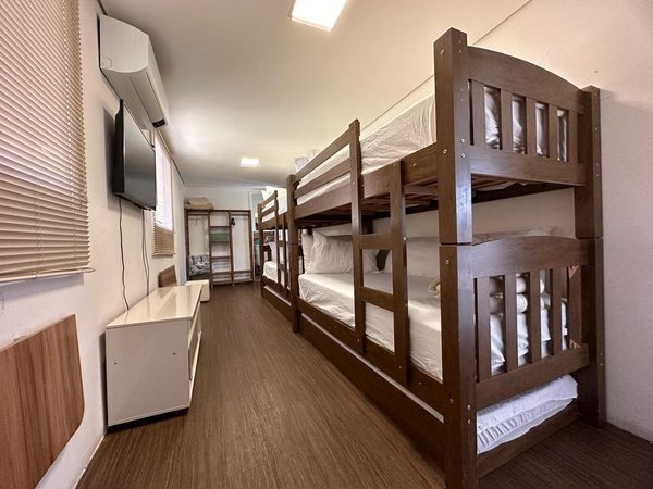 Quarto com beliches de madeira, televisão e armário