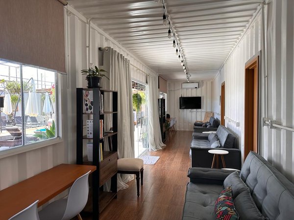 Sala nova com sofás, televisão e janela para a piscina