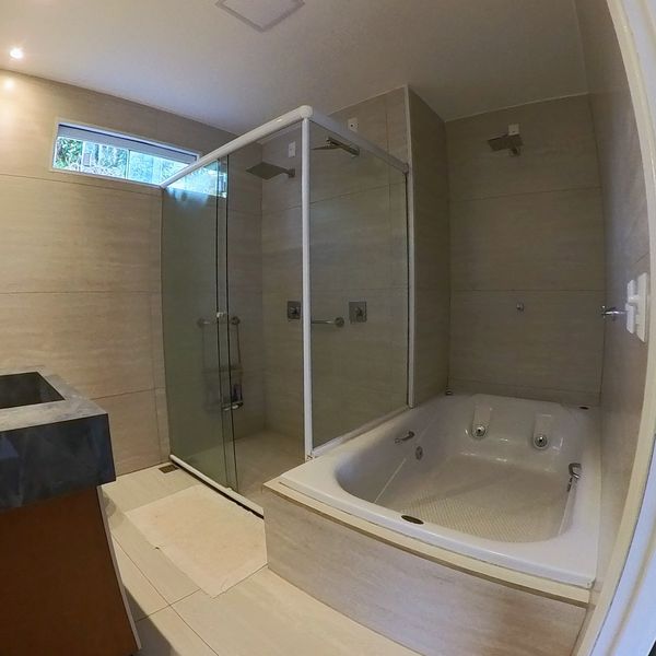 Bañera de hidromasaje y ducha de vidrio de la Suíte do Amor