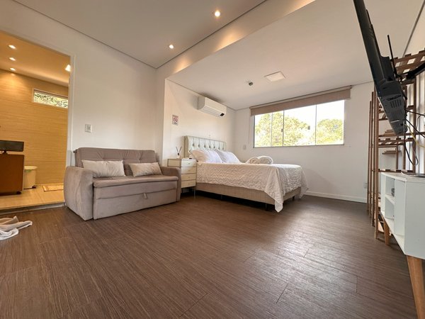 Suíte do Amor da Villa Kubitschek, com cama de casal, sofá e área de estar